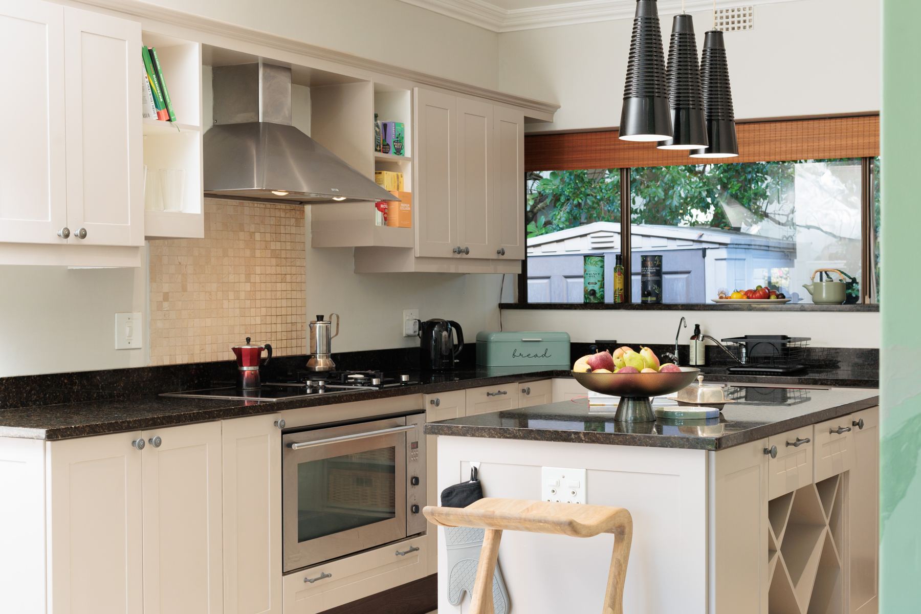 Kitchen with white cabinets and a window over the counter