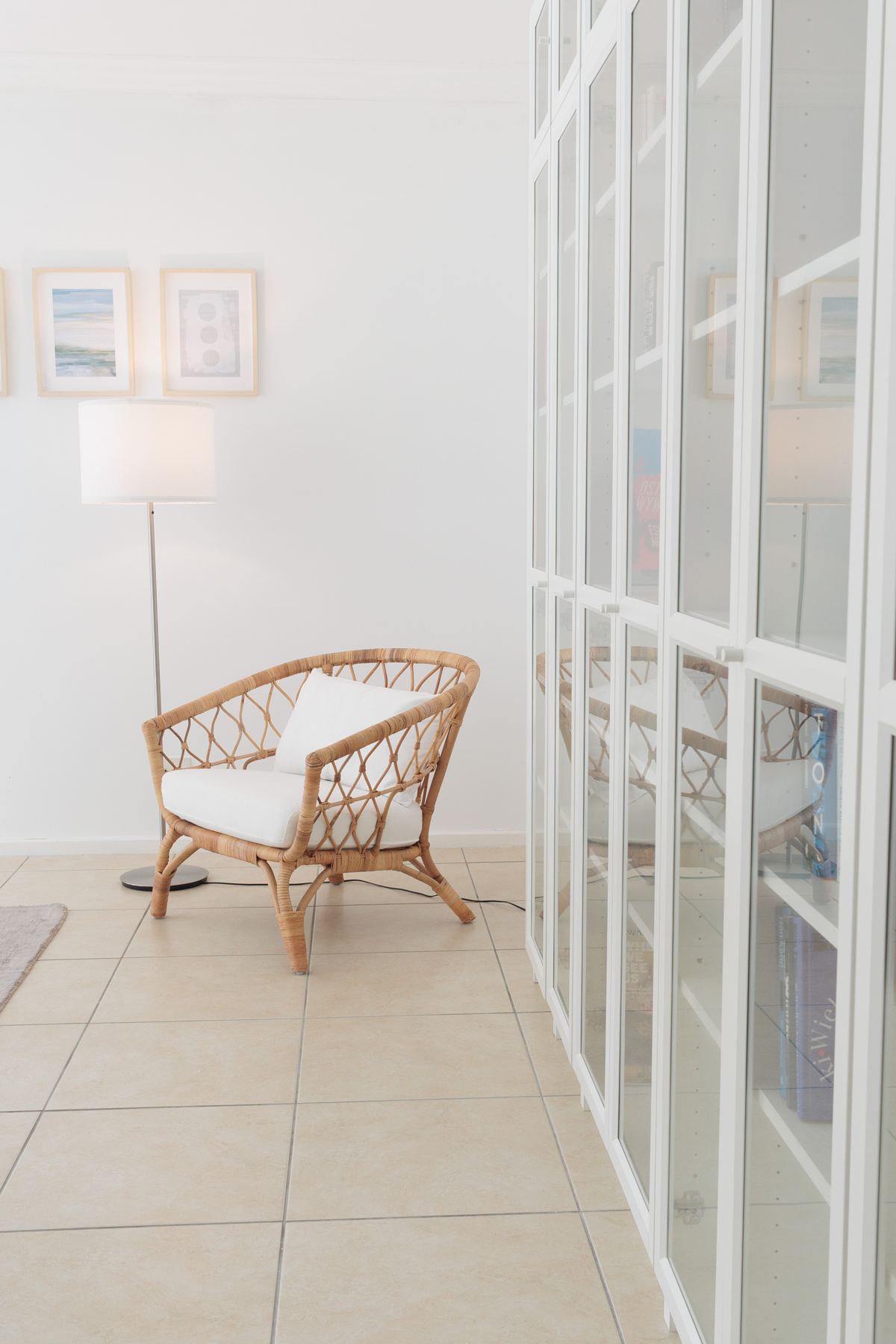 Rattan chair beside tall glazed cabinets