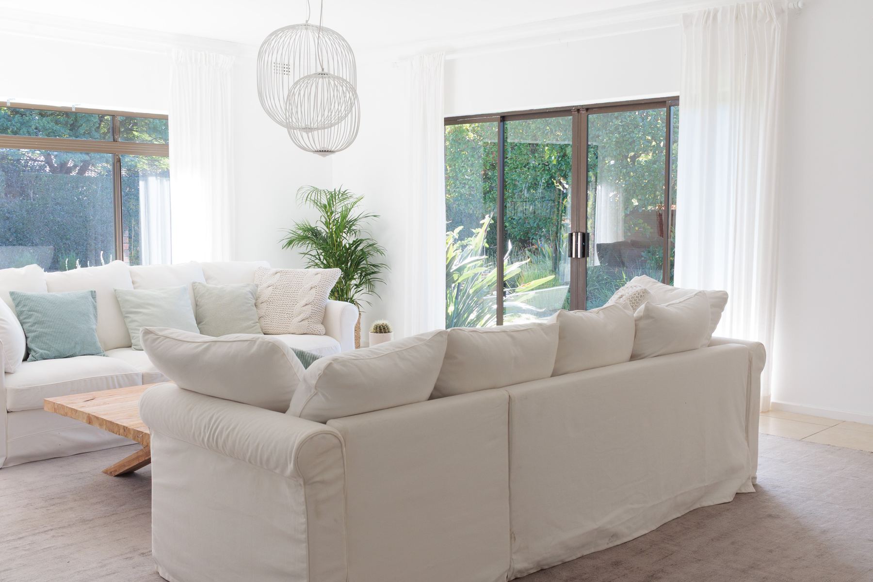 Lounge with white sofas and sliding doors to the garden