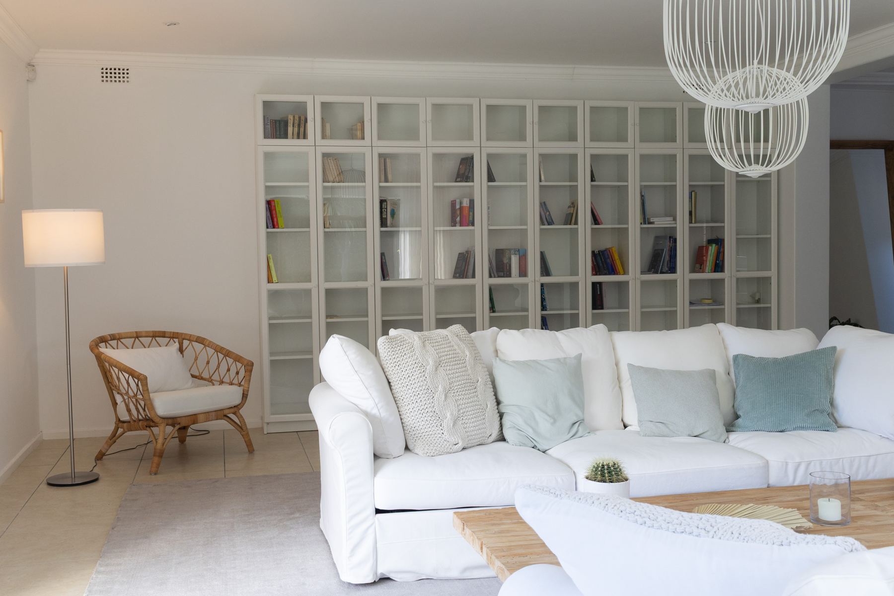 Lounge with a bookcase wall and rattan chair