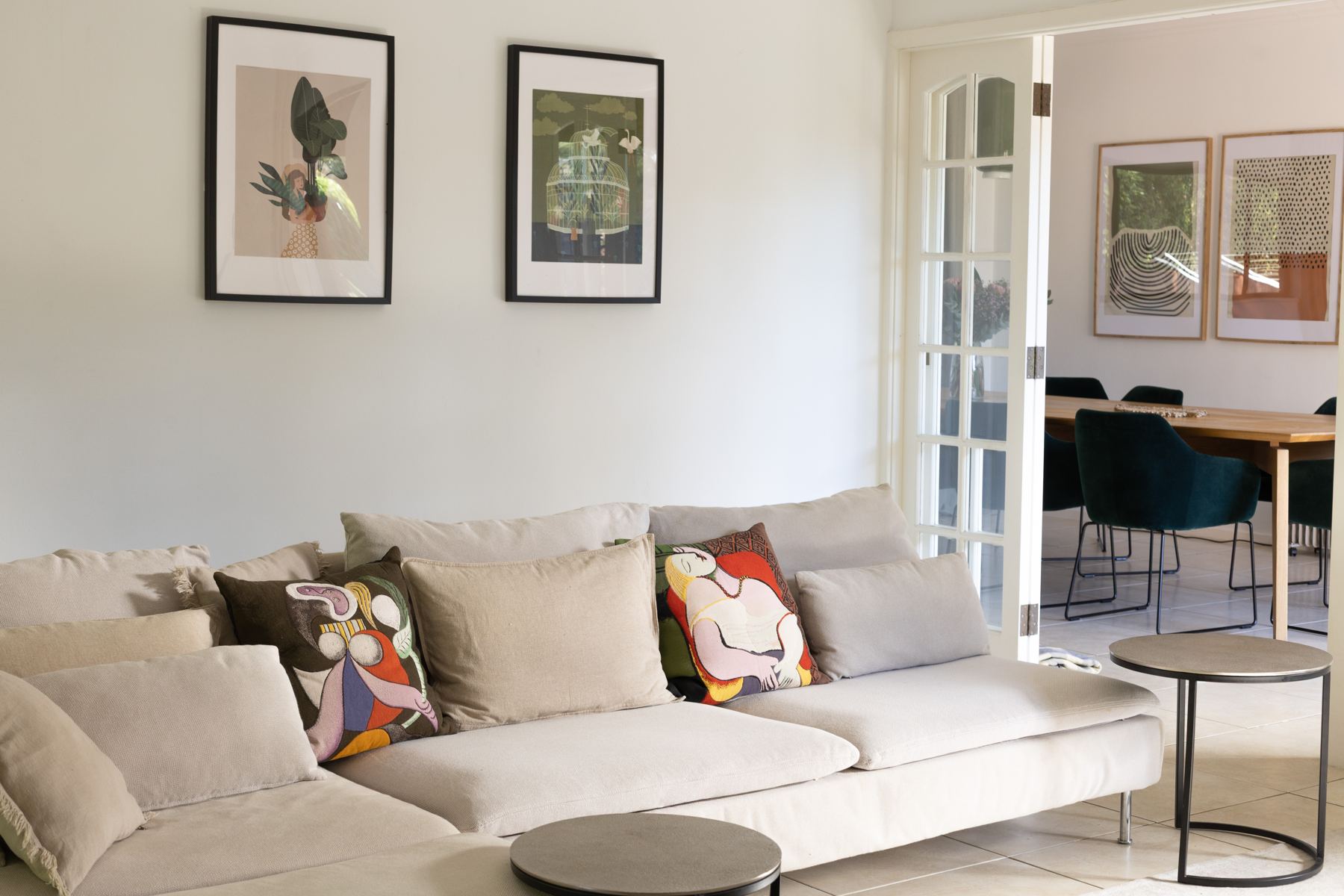 TV room sofa with colourful cushions and the dining table beyond