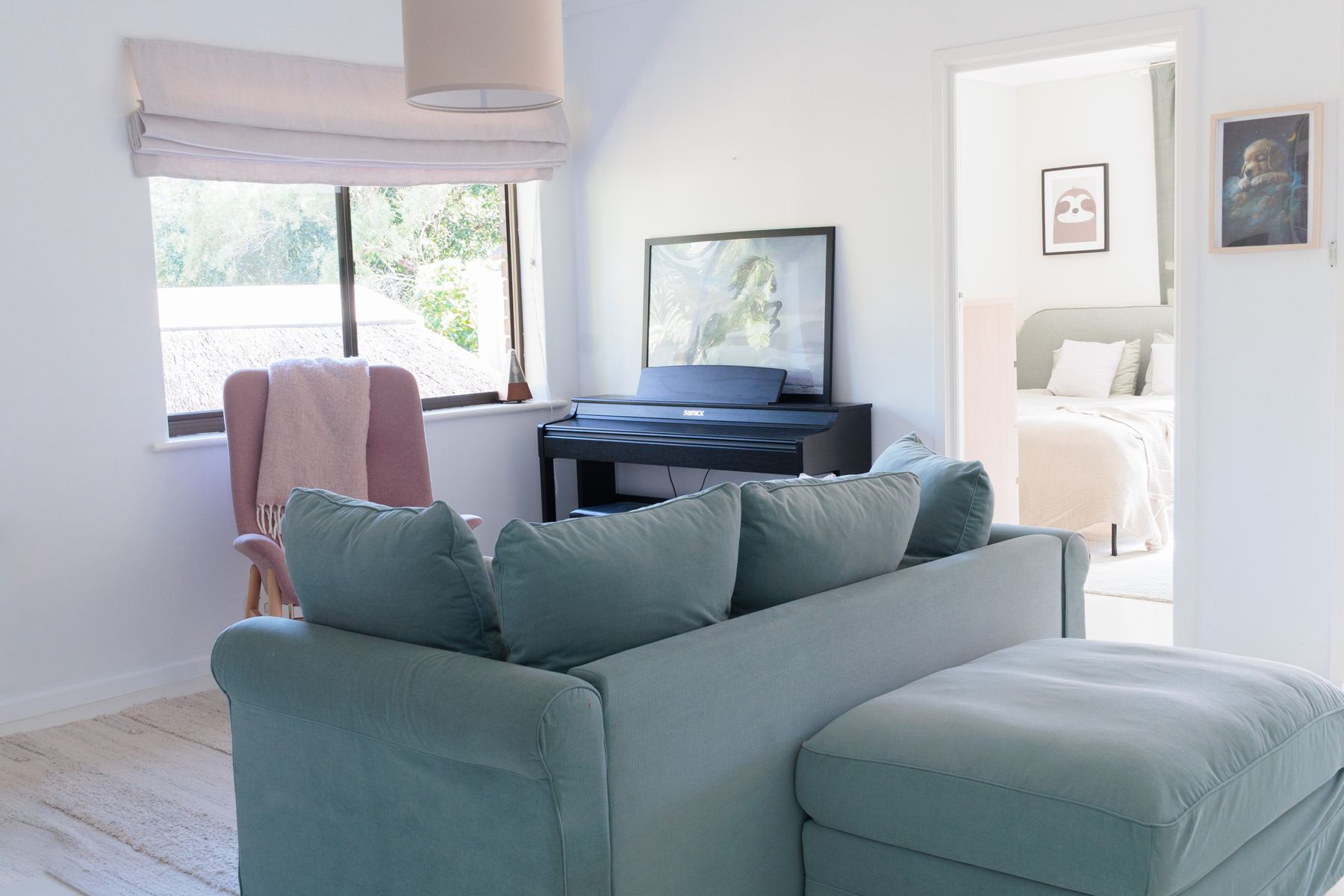 Upstairs lounge with a blue sofa and piano